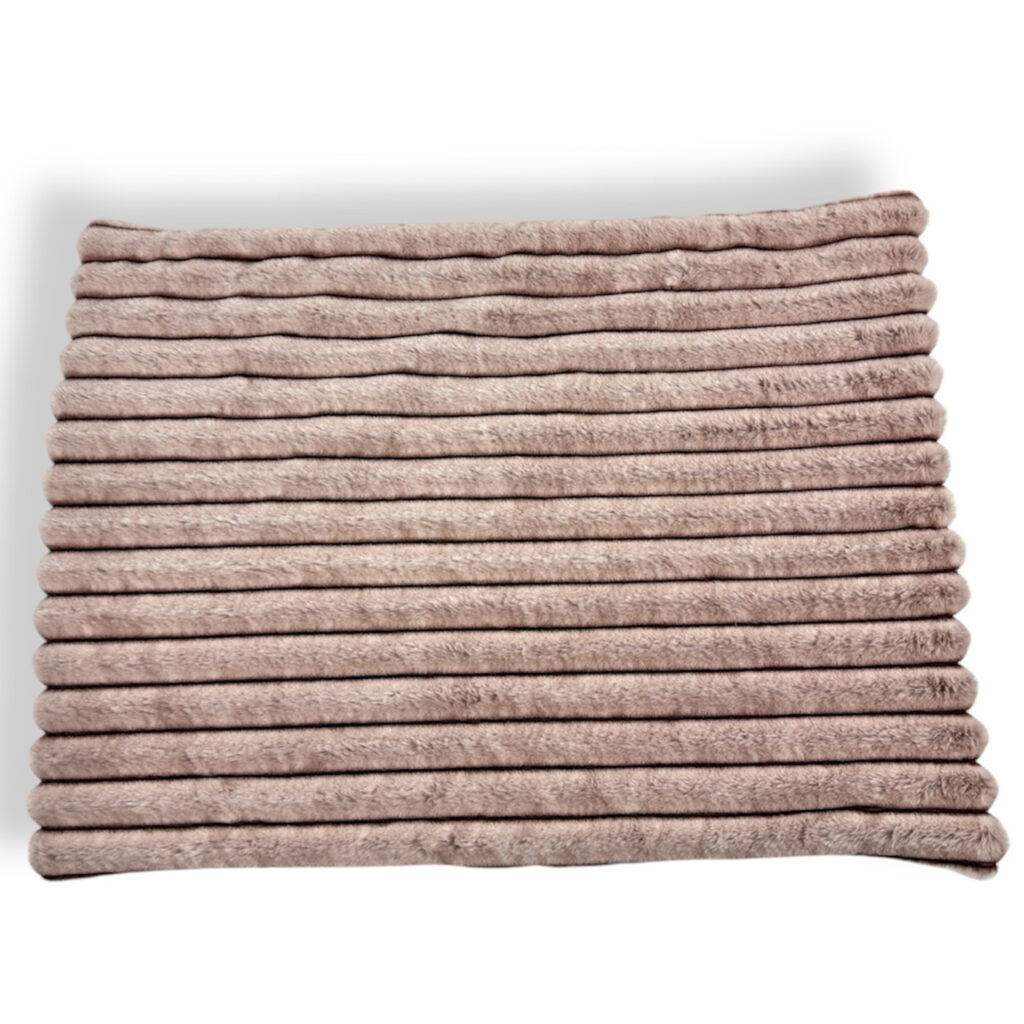 Tappeto di design da viaggio per cani di color rosa cipria e pelliccia ecologica della stessa nuance dove è seduto dolce barboncino marrone che indossa con felpa per cani rosa
