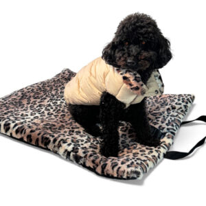Barbone nero su un tappetino da viaggio per cani leopardato con manici tipo borsa, indossando un piumino beige firmato hollyowl